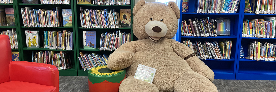 header image of the kids area with a bug teddy bear and places to sit and read