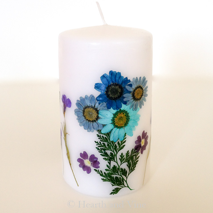 white candle with blue and purple flowers