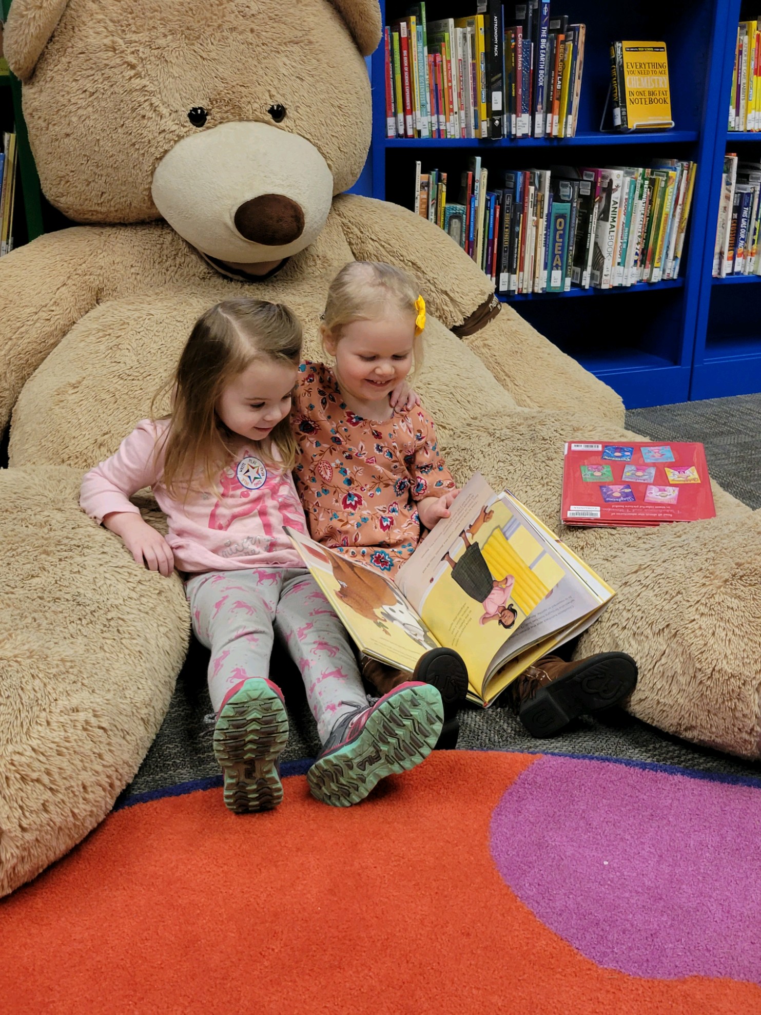Two girls reading on Hoover the Bear