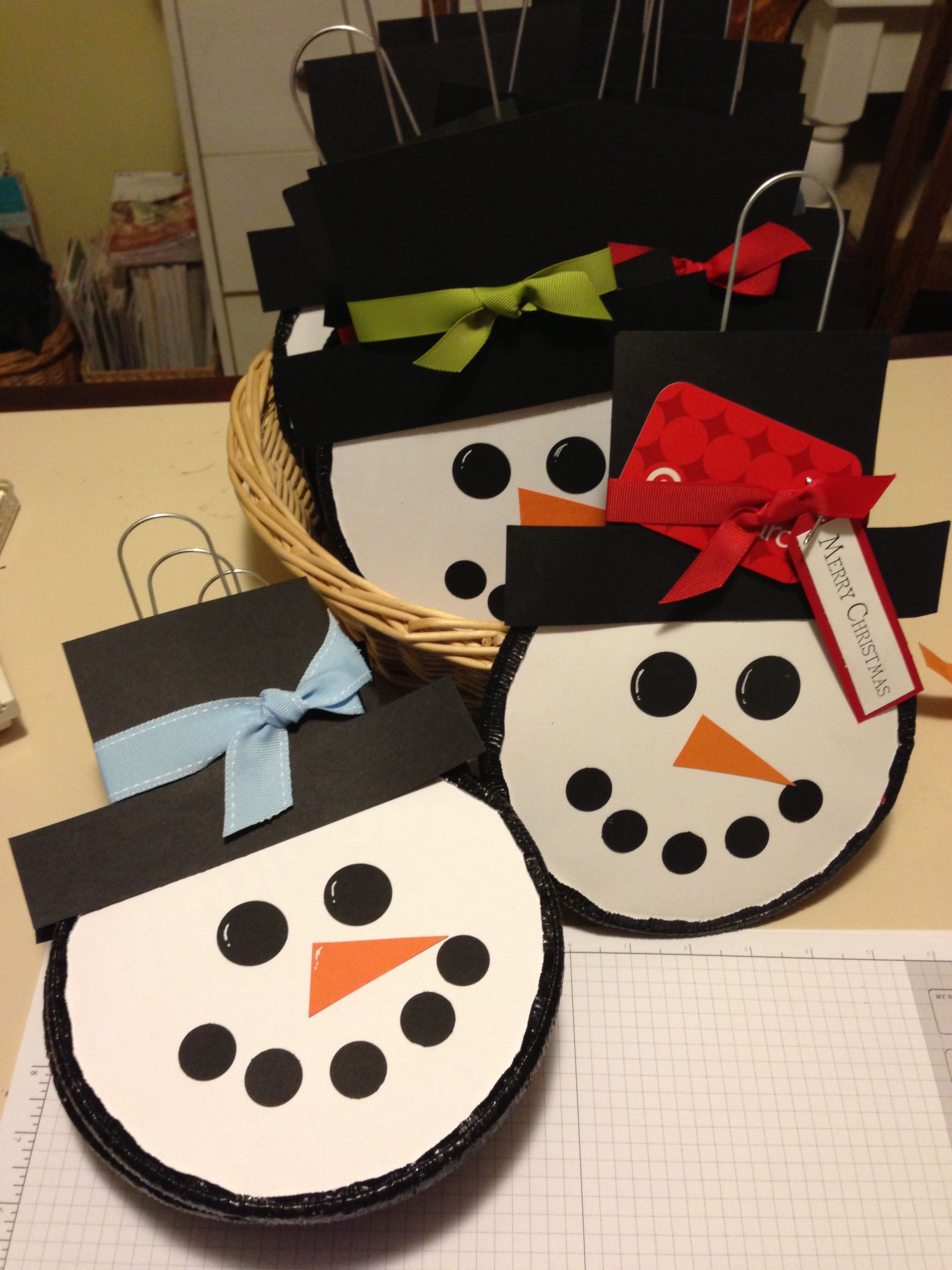 round white snowman head with black hat, black eyes, black circles for mouth and orange triangle nose
