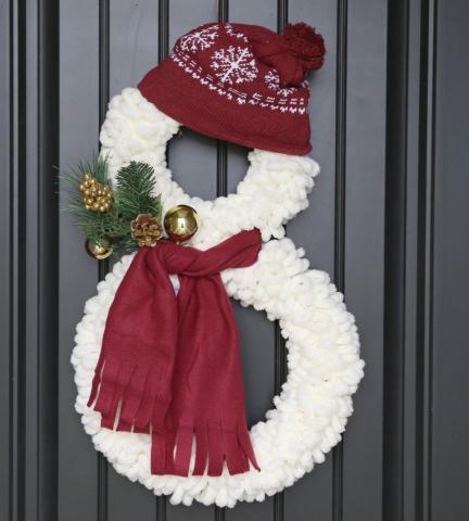 white yarn snowman with red had and scarf