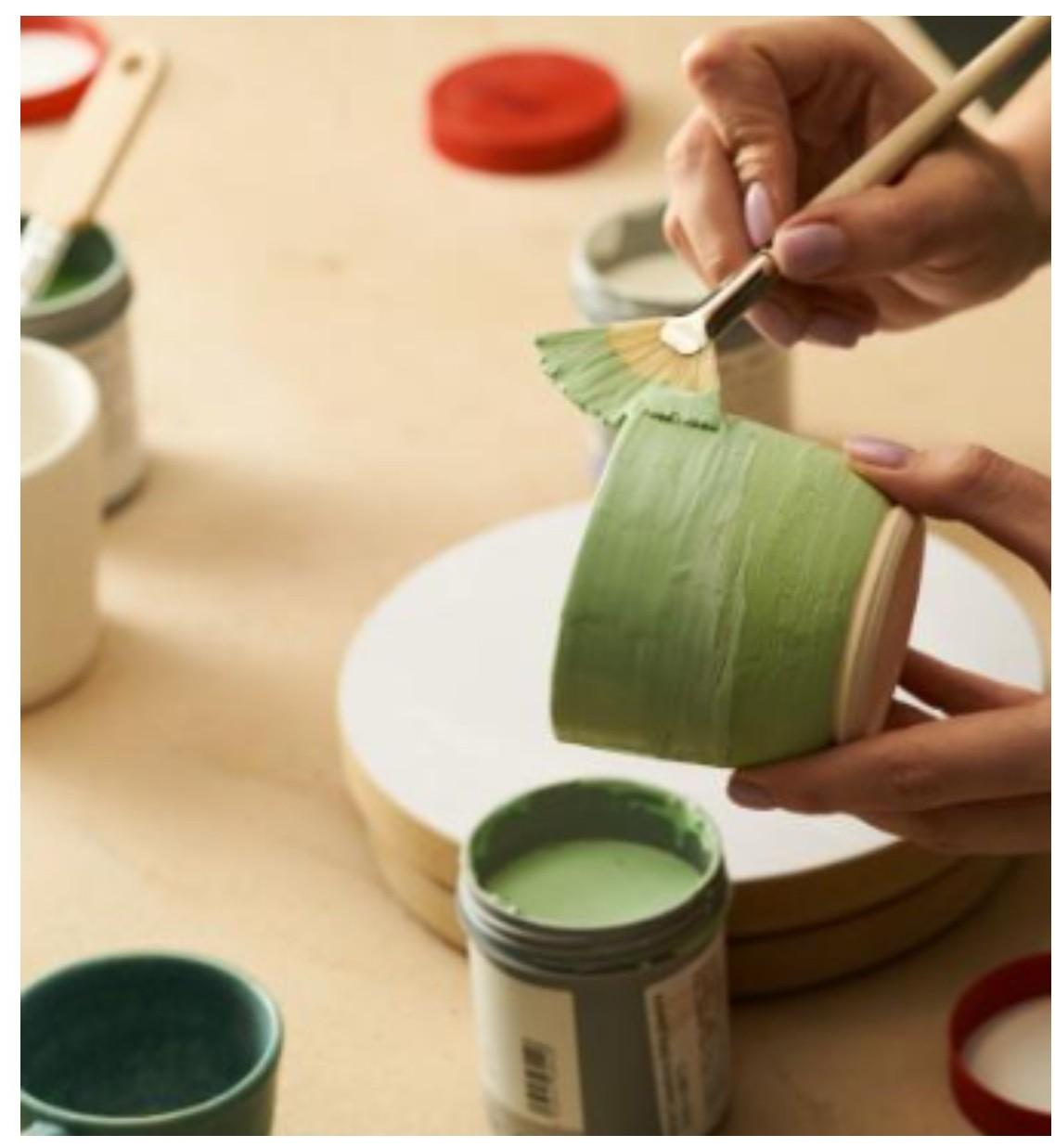 green cup, paint and paint brushes